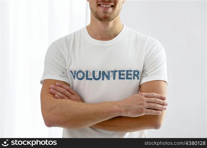 smiley male volunteer posing with arms crossed