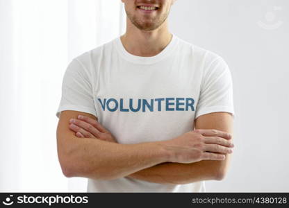 smiley male volunteer posing with arms crossed