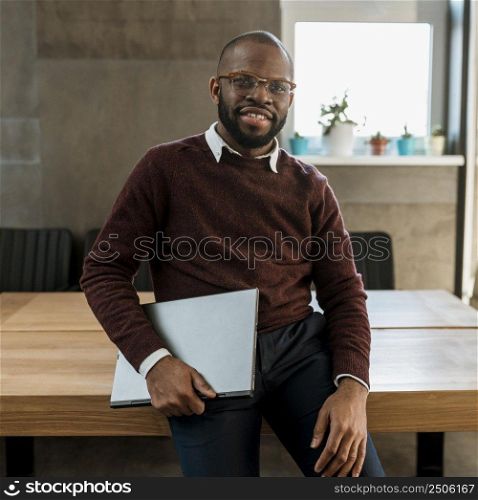 smiley man carrying laptop