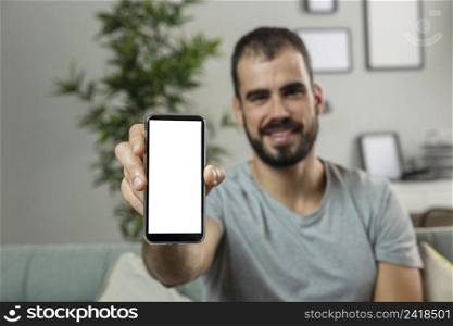 smiley man home holding smartphone