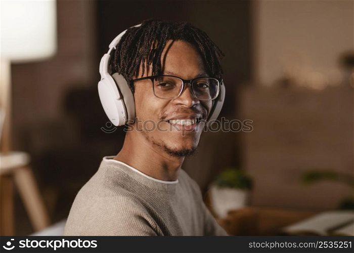 smiley man using modern headphones home