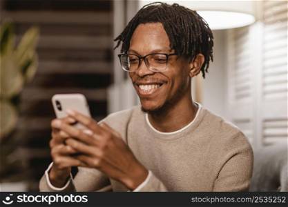 smiley man using modern smartphone device home