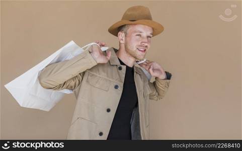 smiley man with brown hat shopping bags