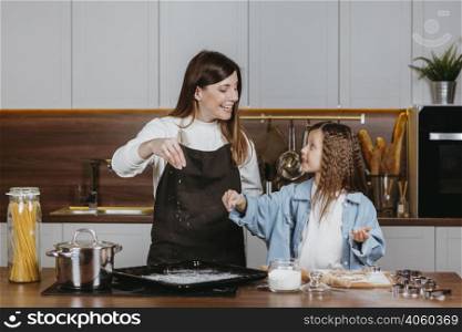 smiley mother daughter cooking together kitchen home