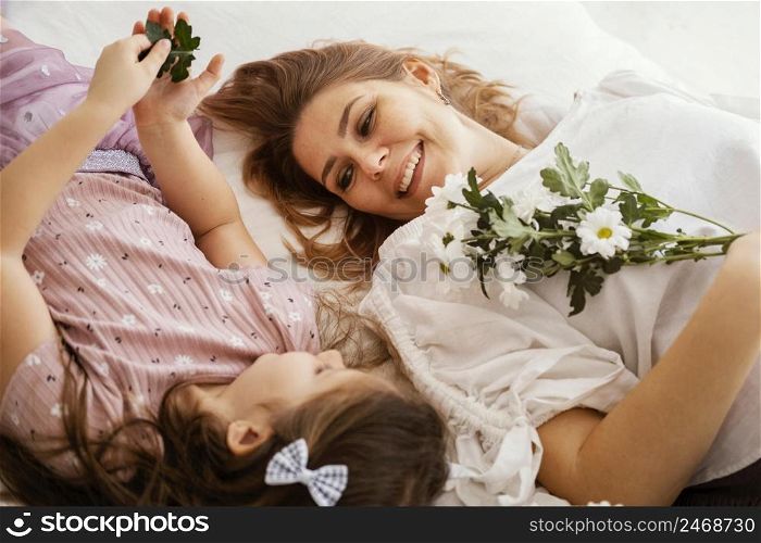smiley mother daughter with bouquet delicate spring flowers