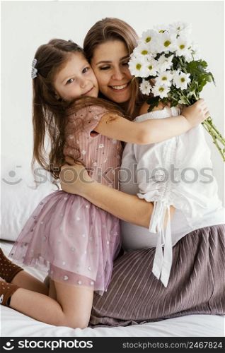smiley mother daughter with bouquet spring flowers