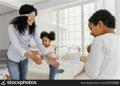 smiley mother playing with her children home