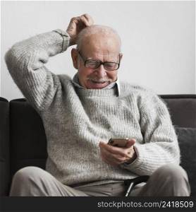 smiley old man nursing home using smartphone
