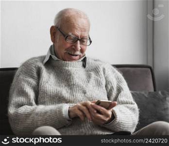 smiley old man using smartphone nursing home