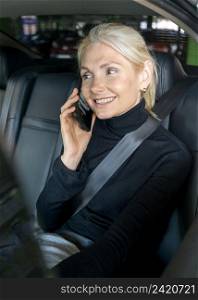 smiley older business woman phone call car