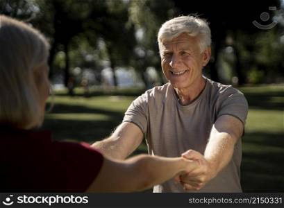 smiley older couple exercising outdoors