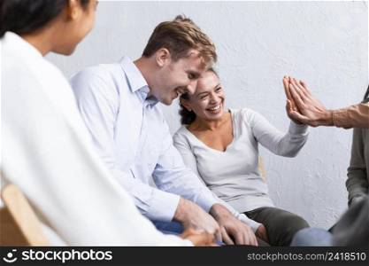 smiley people group therapy session high fiving each other