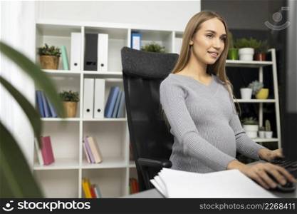 smiley pregnant businesswoman office working computer