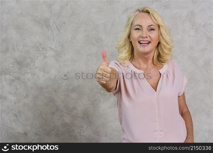 smiley senior woman giving like sign