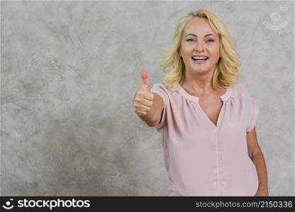smiley senior woman giving like sign