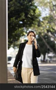 smiley stylish woman talking phone outdoors