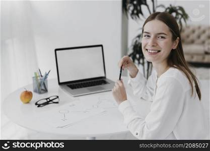 smiley teacher front her laptop