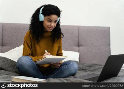 smiley teenage girl using laptop online school
