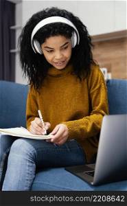 smiley teenage girl with headphones laptop during online school