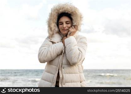 smiley woman beach with winter jacket