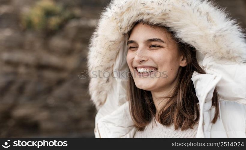 smiley woman beach with winter jacket copy space