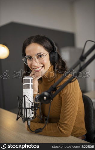 smiley woman broadcasting radio with headphones microphone