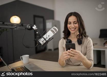 smiley woman doing podcast radio with microphone smartphone