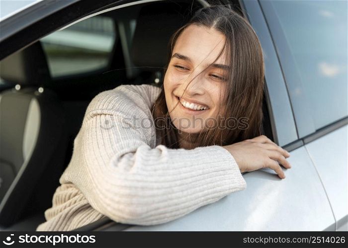smiley woman enjoying road trip her car