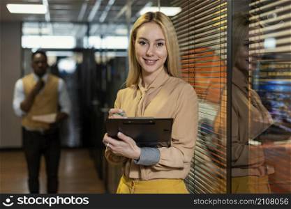 smiley woman holding clipboard workplace