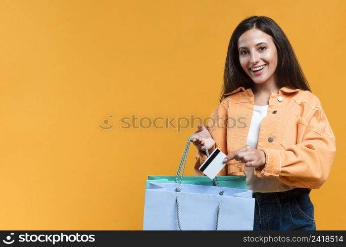 smiley woman holding shopping bag credit card with copy space