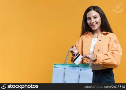 smiley woman holding shopping bag credit card with copy space