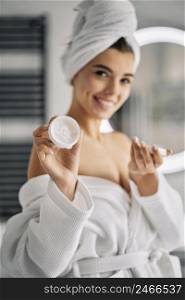 smiley woman holding skincare cream 2
