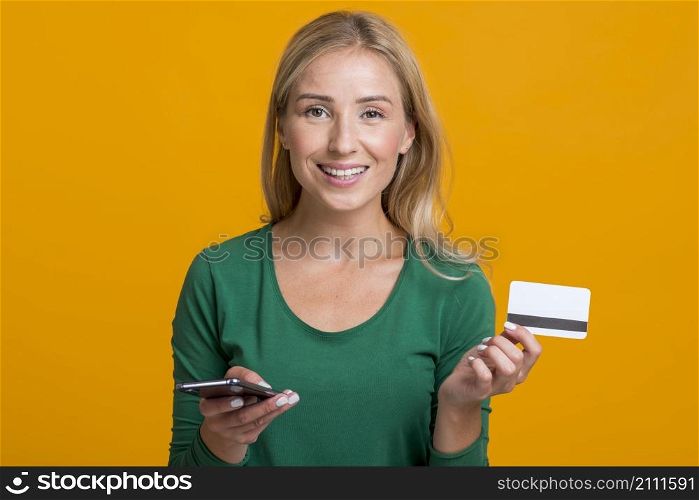 smiley woman holding smartphone credit card