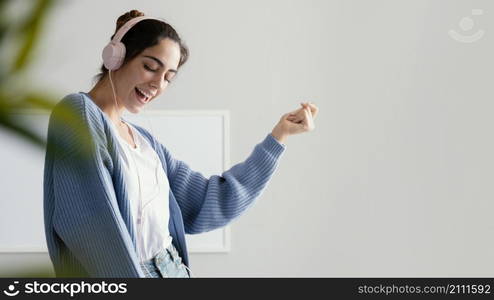 smiley woman listening music headphones with copy space