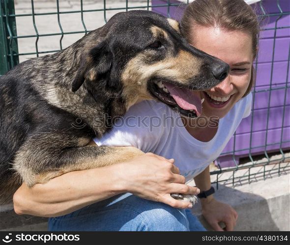smiley woman playing with dog up adoption