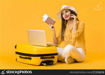 smiley woman posing luggage while holding plane tickets passport