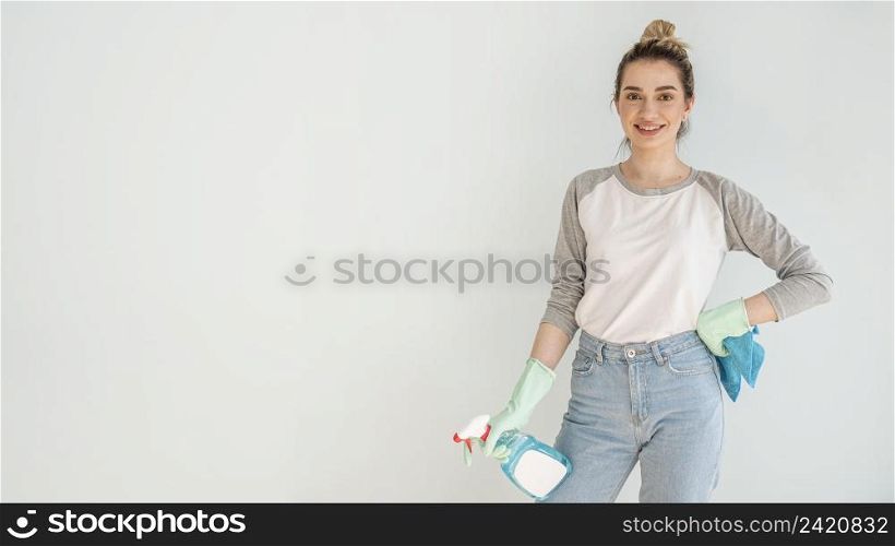smiley woman posing while holding cleaning solution cloth