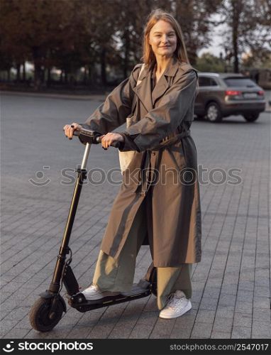 smiley woman posing with her electric scooter city