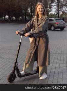 smiley woman posing with her electric scooter city