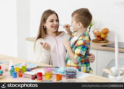 smiley woman son painting eggs