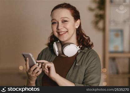 smiley woman using smartphone headphones