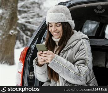 smiley woman using smartphone while road trip