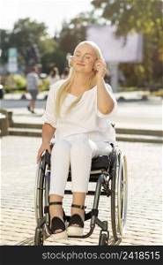 smiley woman wheelchair listening music headphones outside