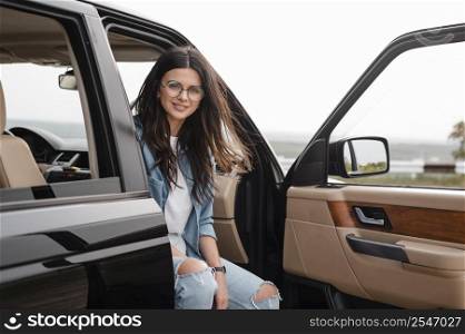 smiley woman with glasses traveling alone by car