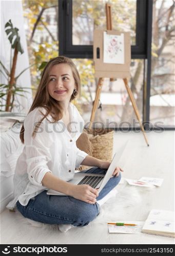 smiley woman with laptop her lap