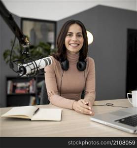 smiley woman with microphone notebook radio studio
