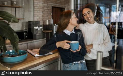 smiley women having coffee during meeting