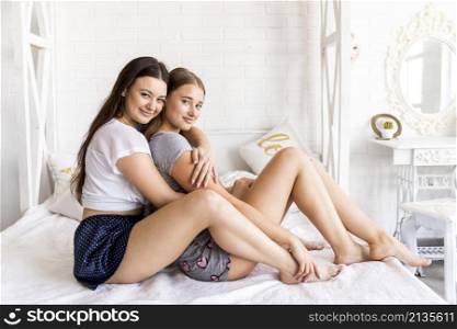smiley women hugging bed