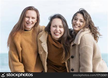 smiley women posing together seaside