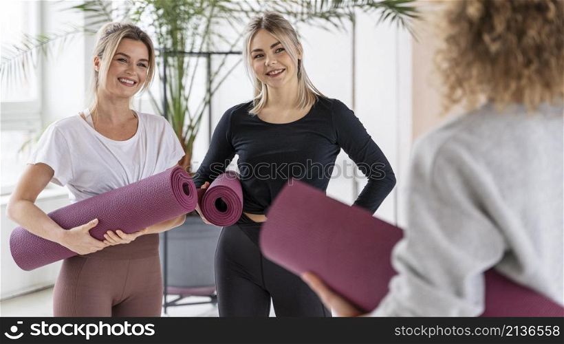 smiley women with yoga mats